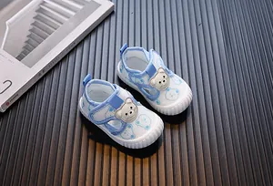 Detalle de zapatos de malla transpirable azul claro para bebé con diseño de oso