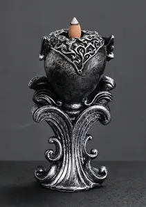 Close-up of a gothic silver resin backflow incense burner featuring intricate scrollwork details