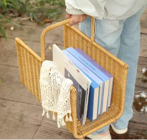 Handheld woven rattan basket carrying books outdoors, detail view
