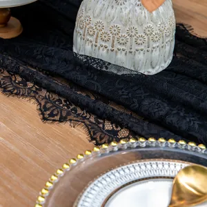Close-up of black lace table runner with intricate floral patterns and eyelash trim