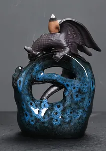 Detail of a ceramic dragon backflow incense burner with blue reactive glaze and smoke.