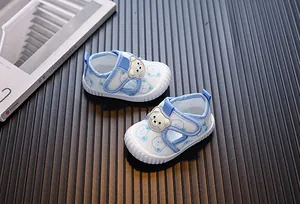 Detalle de zapatos de malla para bebés con estampados de osos animados.