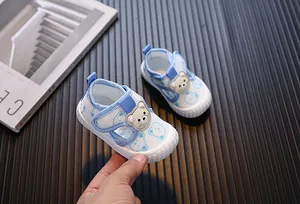 Primer plano de zapatos de bebé transpirables azul cielo con un lindo diseño de oso