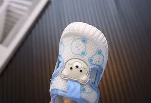 Detalle de zapatos de paseo transpirables para bebé con lindo motivo de oso