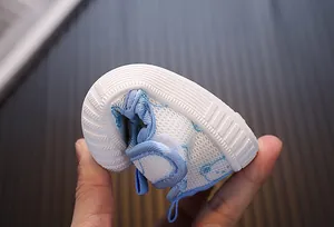 Primer plano que muestra la extrema flexibilidad y suela blanda de zapatos para bebé