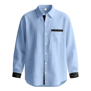 Close-up view of a light blue linen shirt featuring black patterned contrast details