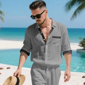 Full body shot of a man wearing a grey linen vacation outfit on a sunny beach resort