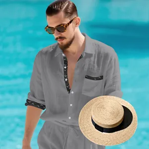 Close-up of a grey linen shirt styled with a classic straw hat for a vacation look