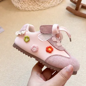 Detailed side view of pink girls' sports shoe with 3D floral embroidery.