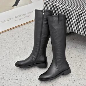 Detail view of elegant black leather knee-high knight boots featuring a side zipper closure