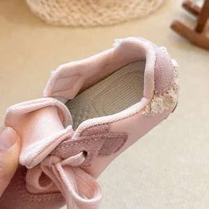 Close-up detail of pink breathable mesh girl's sneaker with lace trim and soft heel