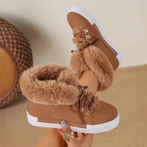 Detailed view of stylish tan women's snow boots with plush fur trim and white rubber soles.