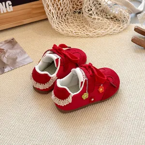 Detailed macro view of red toddler shoes featuring floral patches and lace heel trim