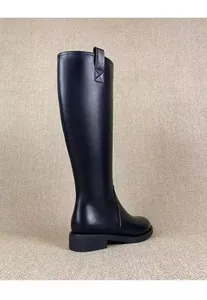 Side view of elegant black knee-high leather knight boots featuring minimalist pull-on loops.