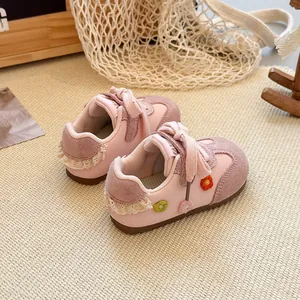 Detailed view of pink toddler girls' sneakers featuring cute floral patches and lace trim.