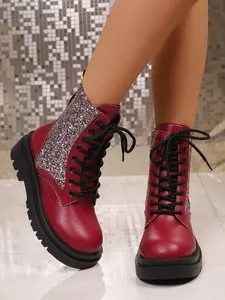 Close-up of red leather boots with glitter side panels and black lace-up details