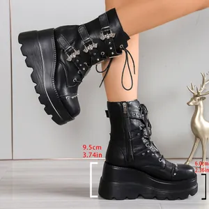 Detalle de botas punk negras con plataforma, tacón de 9,5 cm y hebillas de murciélago.