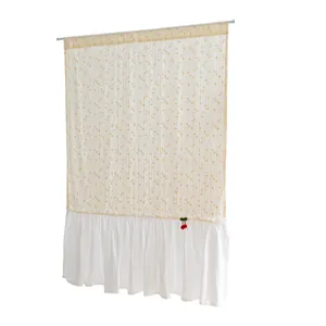 Detail of white cotton short curtain featuring orange dots and a ruffled bottom hem