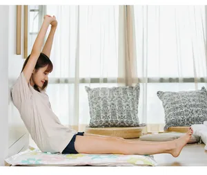 Lifestyle detail showing a person sitting on a durable floral vacuum storage bag at home
