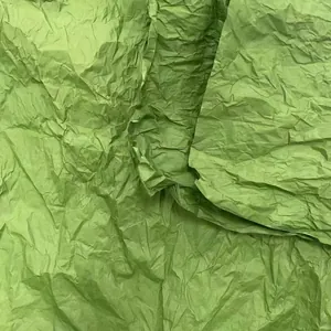 Detailed macro texture of grass green wrinkled tissue paper for DIY floral craft projects