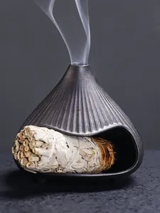 Detail of Mt. Fuji ceramic incense burner with burning white sage bundle and smoke