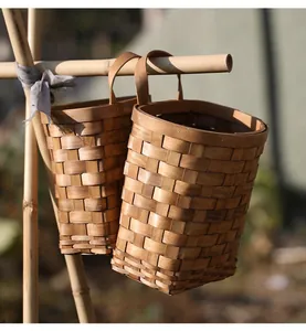Détail de paniers de rangement suspendus tissés à la main en copeaux de bois naturel
