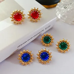 Gros plan de boucles d'oreilles vintage en forme de fleur avec pierres colorées dorées