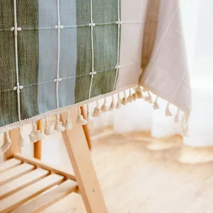 Detailaufnahme einer Leinentischdecke mit Quasten und Karomuster
