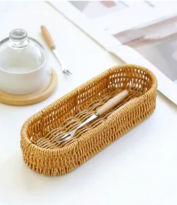 Detailed view of oval woven faux rattan cutlery organizer with wooden forks
