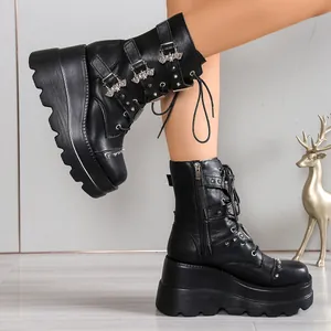 Detalle de botas punk negras con plataforma, remaches plateados y adornos de murciélago de metal