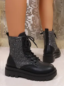 Close-up detail showing silver glitter panels on black leather lace-up platform boots
