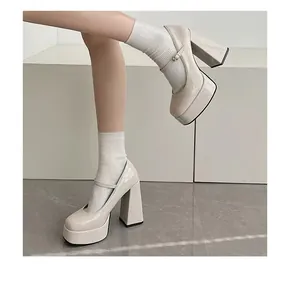 Detaillierte Nahaufnahme der beige Lackleder Plateau Mary Jane High Heels am Fuß
