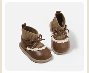 Detail view of brown toddler girl sock boots with lace trim and bow accent