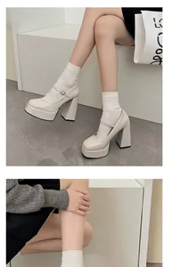 Detailansicht von cremefarbenen Plateau-Mary-Jane-Pumps mit einem dicken Blockabsatz.