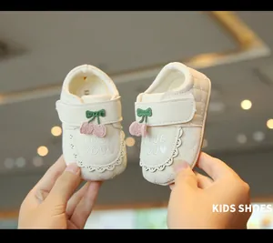 Détail de chaussures bébé blanches avec décor cerise et broderie Love You élégante