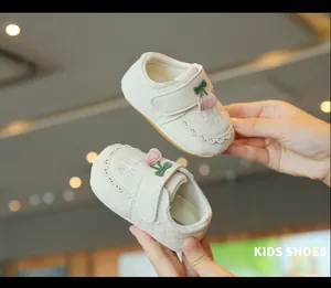 Gros plan de chaussures de marche bébé blanc cassé avec cerise et broderie LOVE YOU
