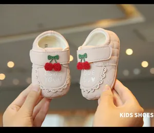 Vue détaillée de chaussures de marche roses pour bébé avec cerise et broderie