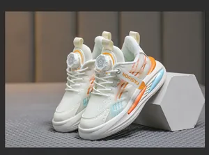 Détail latéral des baskets en mesh respirant pour garçons avec touches orange et système de cadran