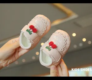 Détail de chaussures de marche roses pour bébé avec broderie cerise et semelle souple