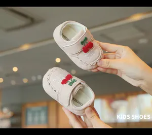 Vue détaillée de chaussures de marche bébé roses avec broderie cerise 3D et dentelle