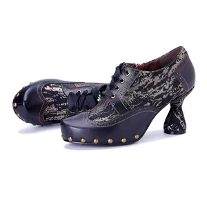 Dettaglio di scarpe col tacco in pelle fatte a mano con borchie dorate e cuciture a contrasto