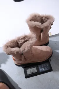 Dettaglio di stivali da neve da donna foderati in pelliccia pesati su una bilancia