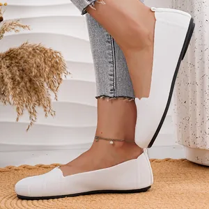 Detail view of breathable white knit slip-on flat shoes with comfortable round toe design