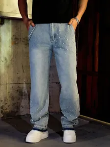 Detail view of men's straight-leg jeans with elegant pearl embellishments and washed blue denim