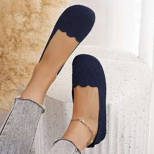 Detail view of navy blue fly-knit round-toe flat shoes with elegant scalloped edges