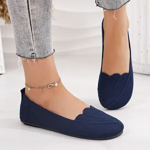 Close-up detail of navy blue flyknit slip-on ballet flats featuring a textured scallop edge
