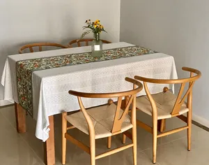 Elegant French white embroidered lace tablecloth on wooden table in cozy dining room scene