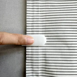 Close-up of white plastic slider clip sealing a striped fabric vacuum storage bag