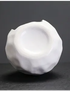 Detalle de la base de un contenedor de cerámica blanca con textura irregular