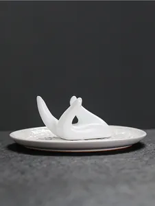 Detail van witte keramische handhouder op een reliëf tray voor salie en Palo Santo